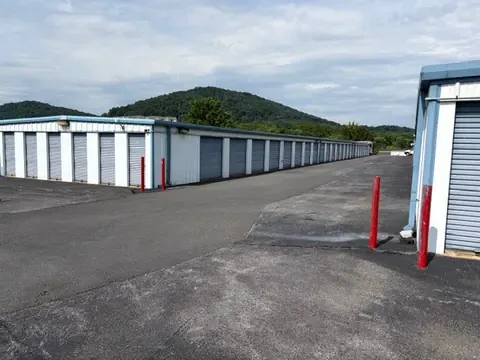Long row of drive-up storage units along a paved aisle with Shenandoah Valley mountains in the background at American Mini Storage in Staunton, VA