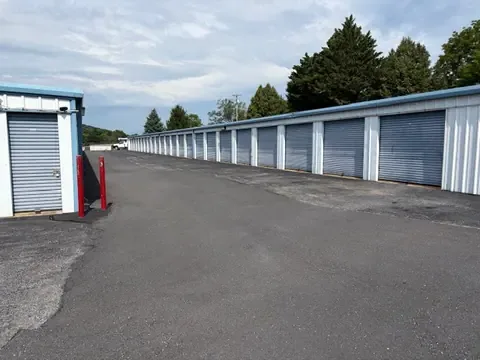 Wide paved drive aisle running between two long rows of drive-up storage units, easy turning room for trucks and trailers at American Mini Storage in Staunton, VA